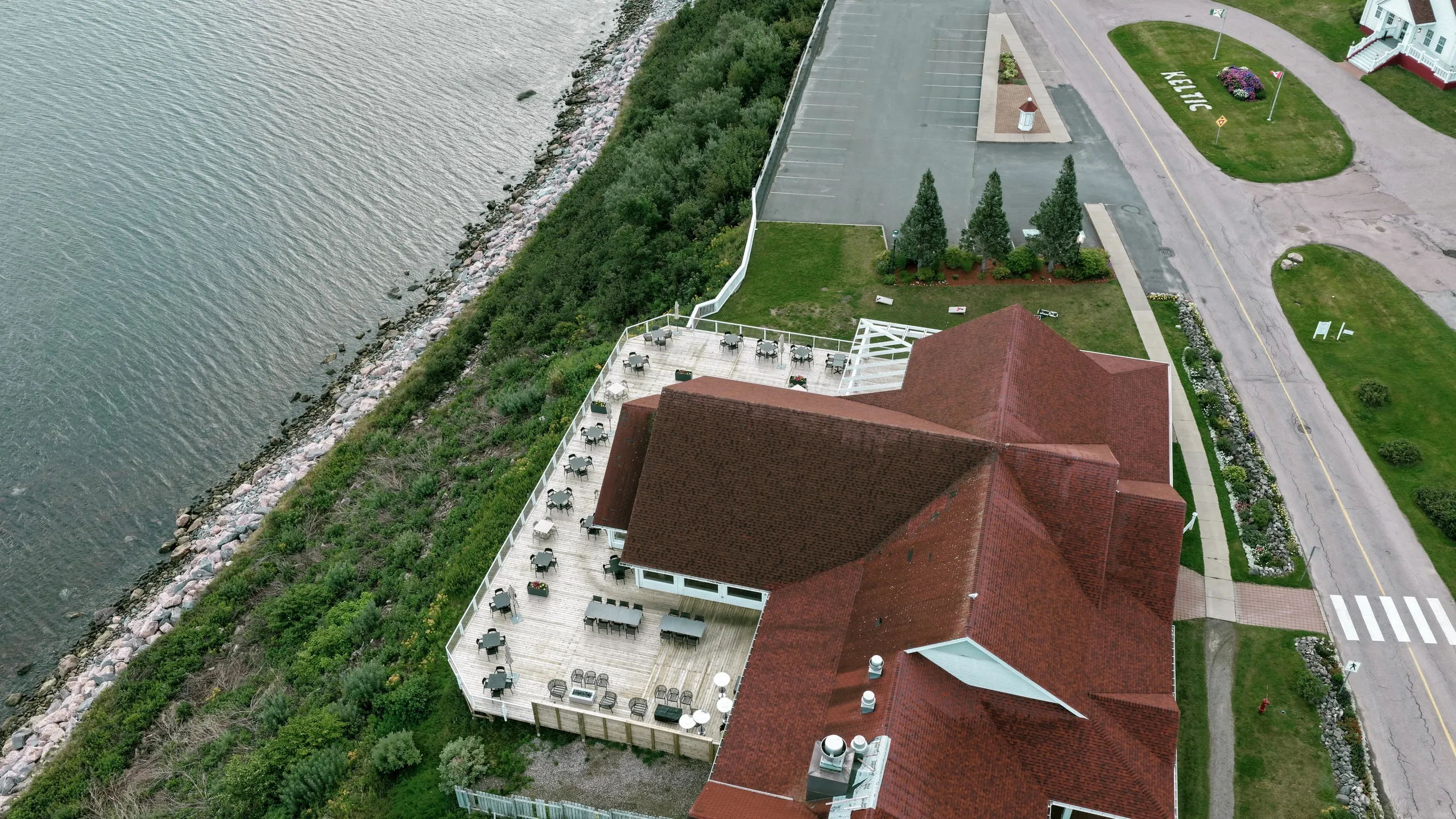 Aerial view of the coastline, road, and red roof beside the Atlantic.