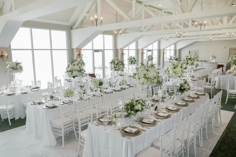 Round tables set for an event in a bright hall.