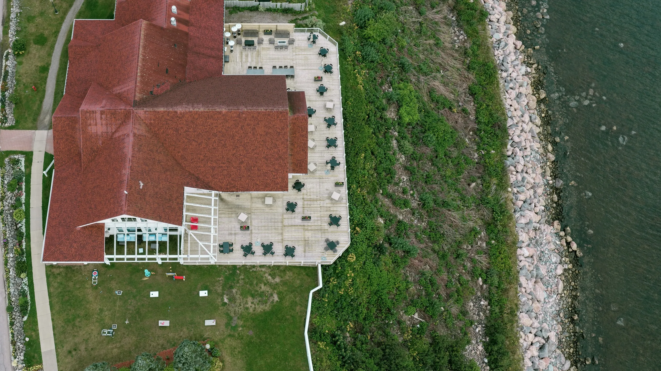 Aerial view of the red-roofed patio and dining room along the shore.